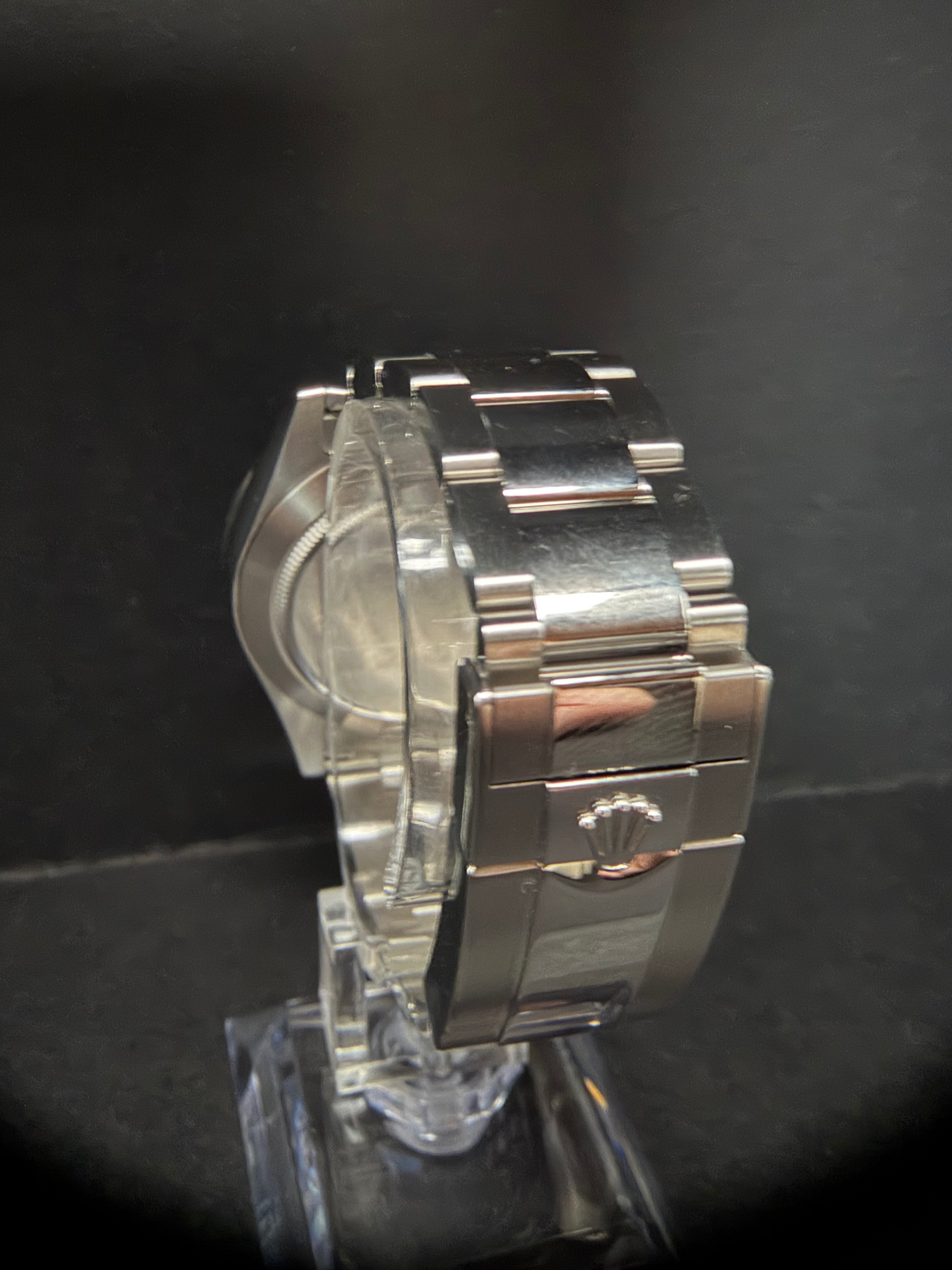 2015 Rolex Cosmograph Daytona 116520 side profile on stand showing crown, pushers, and Oyster bracelet
